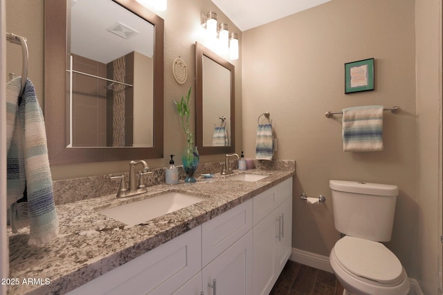 bathroom with tiled shower, vanity, and toilet