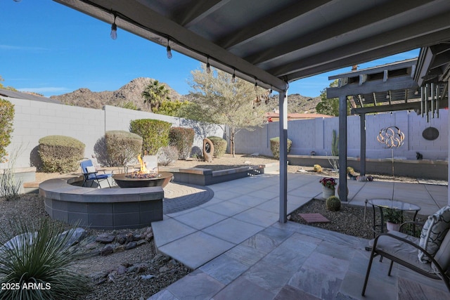 view of patio / terrace featuring a mountain view and an outdoor fire pit