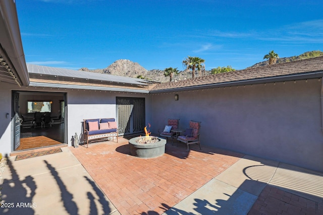 view of patio / terrace with a mountain view and a fire pit