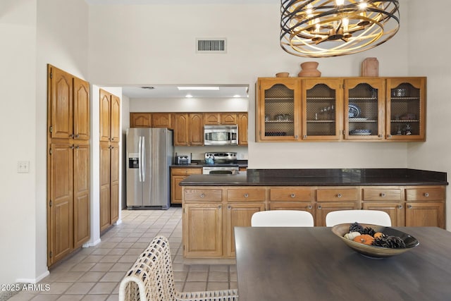 kitchen with decorative light fixtures, light tile patterned floors, stainless steel appliances, and a chandelier