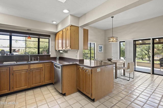 kitchen featuring dishwasher, sink, decorative light fixtures, light tile patterned flooring, and kitchen peninsula