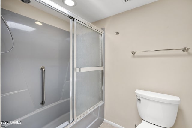 bathroom with combined bath / shower with glass door and toilet