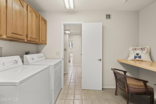 laundry area with washer and clothes dryer and cabinets