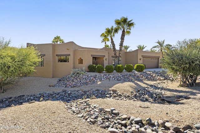 pueblo-style house featuring a garage