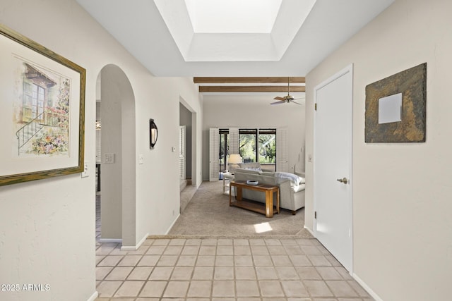 hallway with beam ceiling and light colored carpet