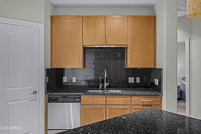 kitchen featuring dark stone counters, backsplash, sink, and stainless steel dishwasher