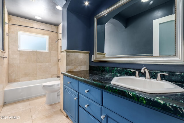 full bathroom with tile patterned flooring, tiled shower / bath, vanity, and toilet