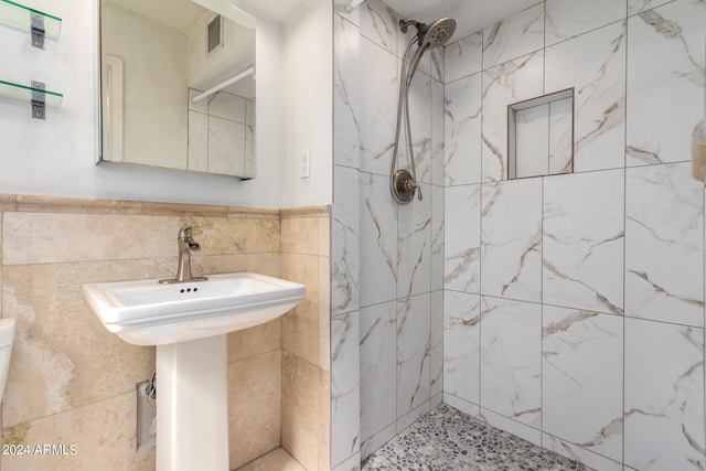 bathroom featuring tile walls and tiled shower