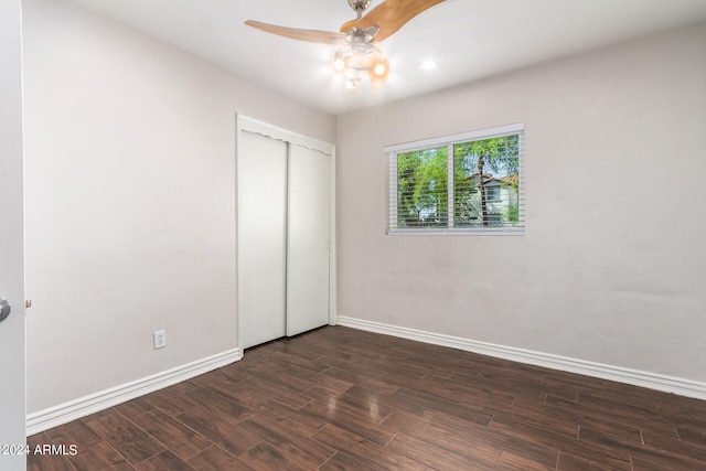 unfurnished bedroom featuring a closet, ceiling fan, and dark wood-type flooring