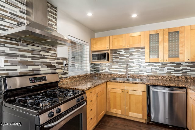 kitchen featuring island range hood, stainless steel appliances, dark stone counters, dark hardwood / wood-style floors, and sink