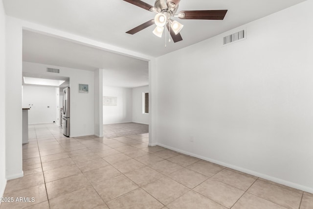 spare room featuring visible vents, ceiling fan, and light tile patterned flooring