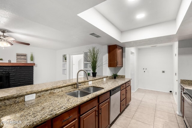 kitchen with dishwasher, a sink, visible vents, and light stone countertops