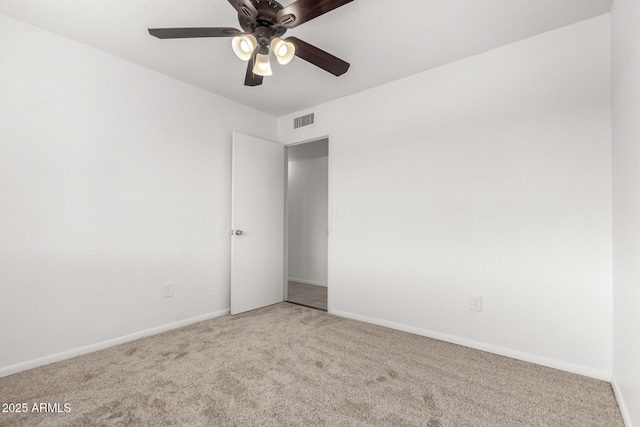 unfurnished room featuring carpet floors, visible vents, baseboards, and ceiling fan