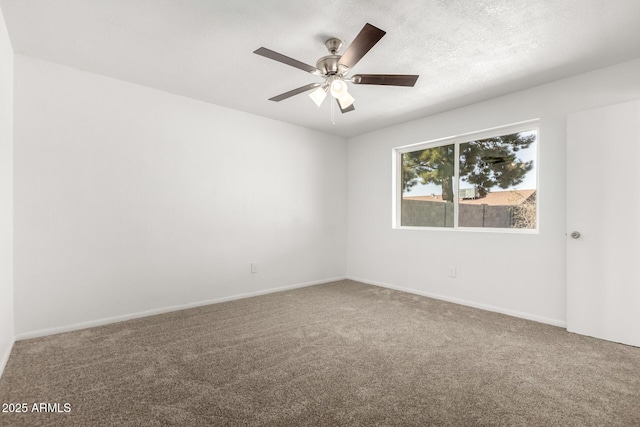 carpeted empty room with a textured ceiling, a ceiling fan, and baseboards