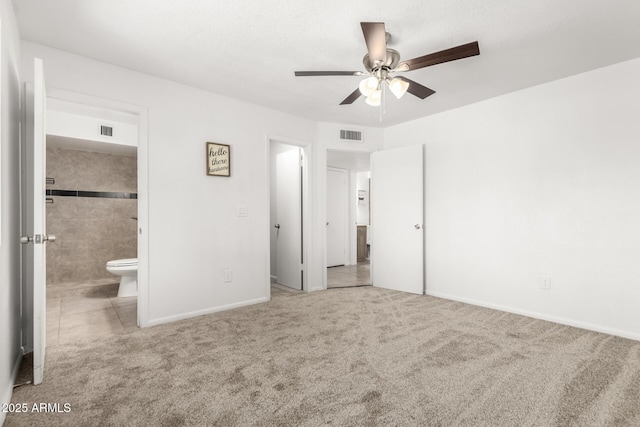 unfurnished bedroom with baseboards, carpet flooring, visible vents, and connected bathroom