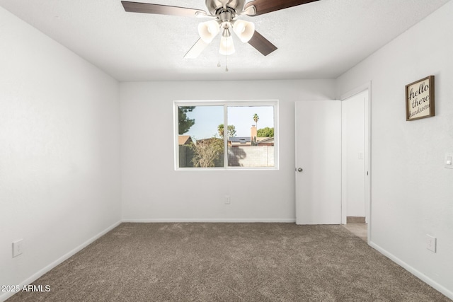 empty room with a ceiling fan, carpet, a textured ceiling, and baseboards