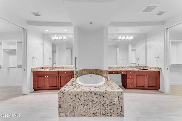 bathroom with vanity and a relaxing tiled tub