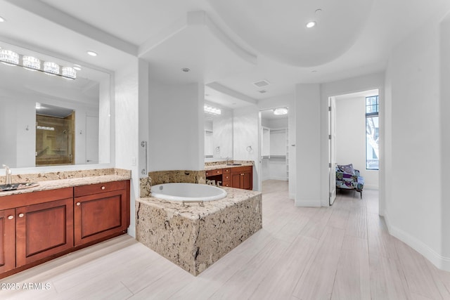 bathroom with vanity and shower with separate bathtub