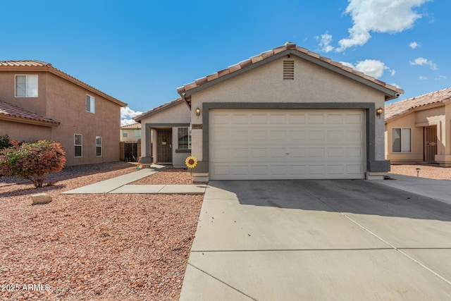 view of front of house with driveway, an attached garage, a tiled roof, and stucco siding