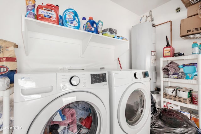 washroom featuring laundry area, washing machine and dryer, and electric water heater