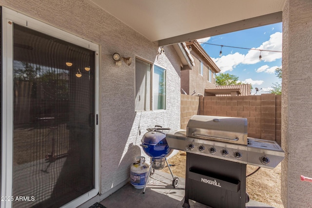 view of patio featuring a grill and fence