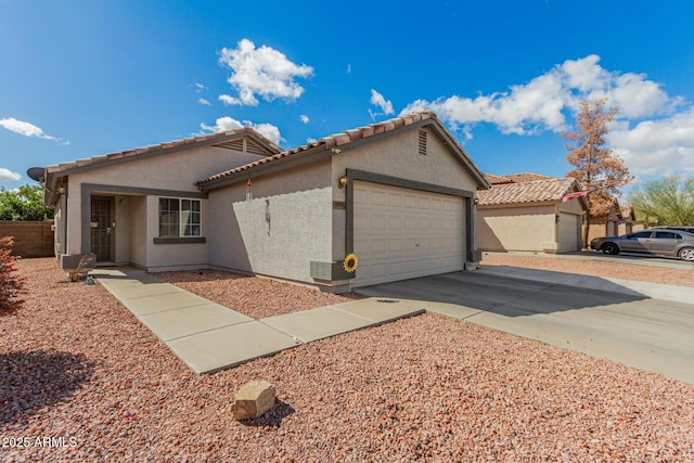 view of front of property with concrete driveway, an attached garage, a tiled roof, and stucco siding