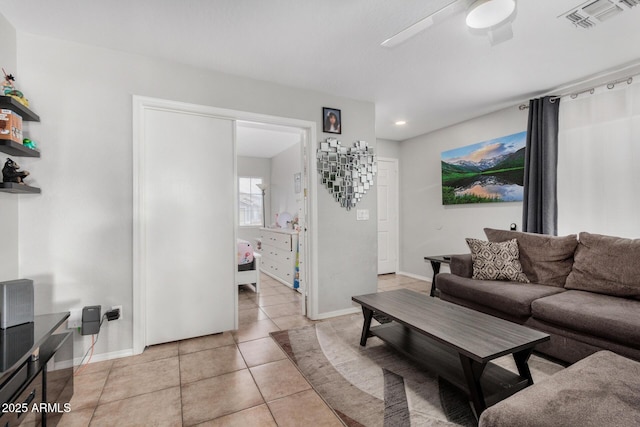 living room with visible vents, ceiling fan, baseboards, and light tile patterned floors