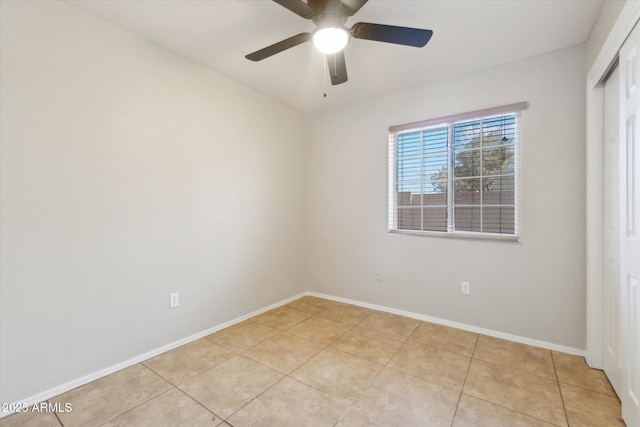 spare room with ceiling fan and light tile patterned floors