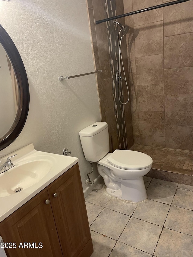 full bath featuring tile patterned flooring, a shower stall, vanity, and toilet