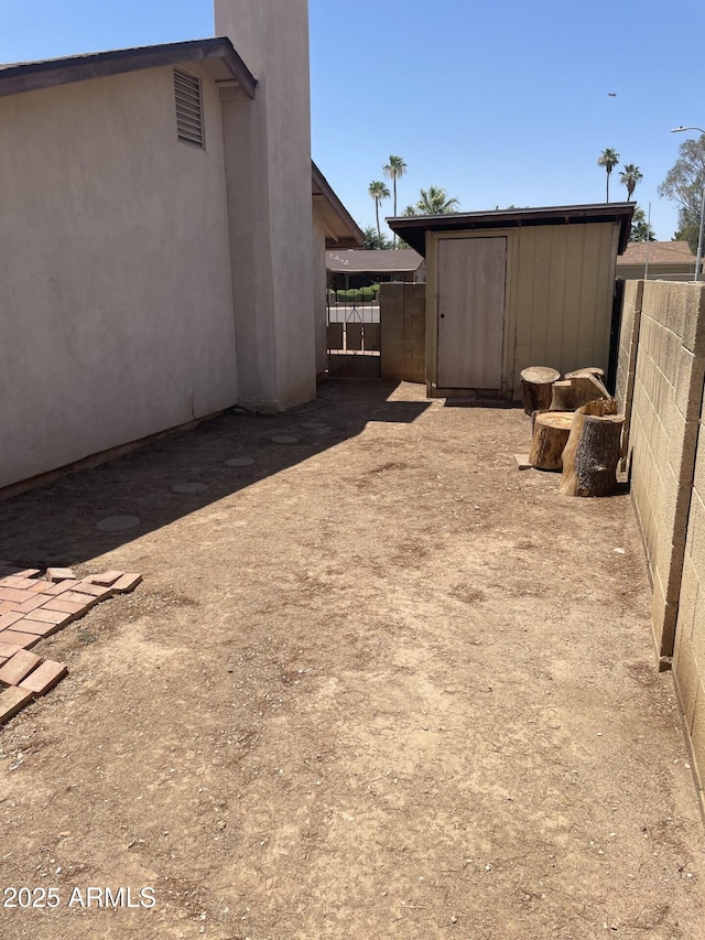 view of yard featuring an outbuilding, fence, and a storage unit