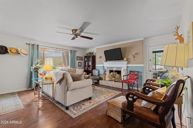 living room with a tiled fireplace, hardwood / wood-style floors, and ceiling fan