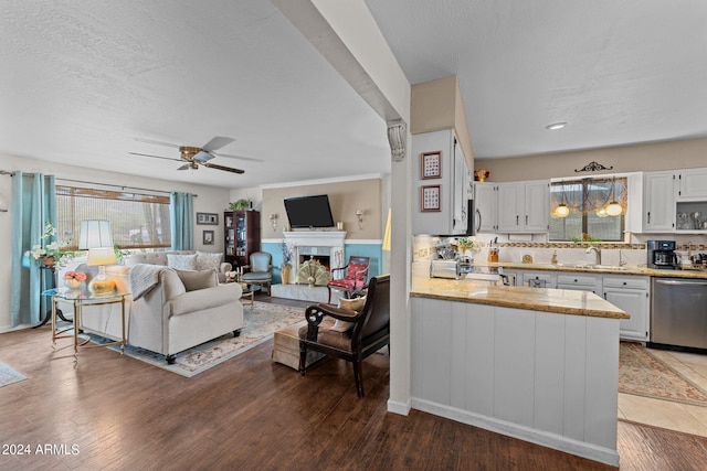 living room featuring ceiling fan, sink, hardwood / wood-style floors, and a textured ceiling