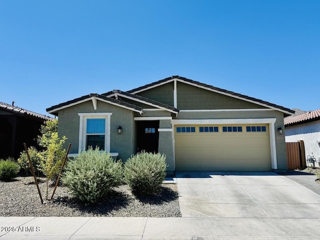1657 W Monte Way, Phoenix, AZ 85041 - view of front of house featuring driveway, an attached garage, and stucco siding