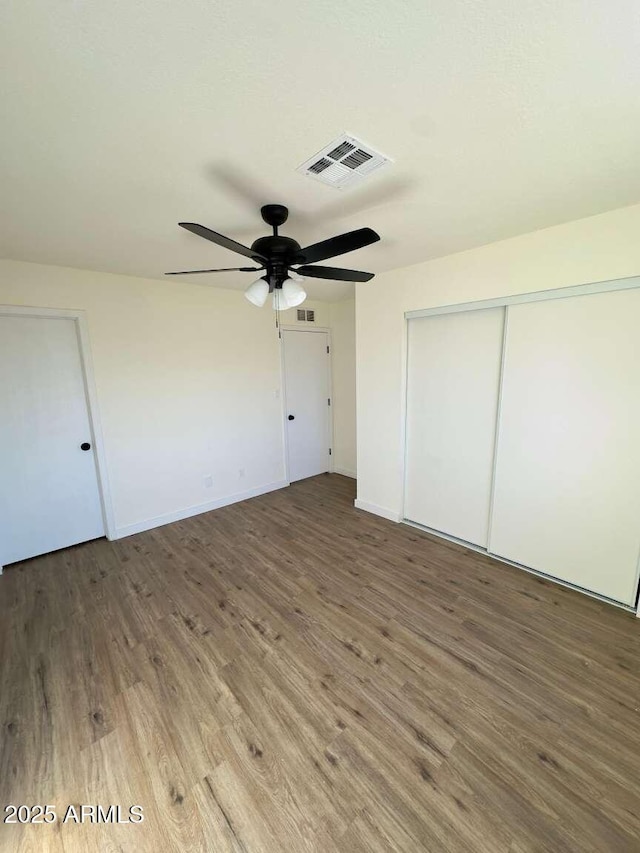 unfurnished bedroom with ceiling fan, hardwood / wood-style floors, and a closet