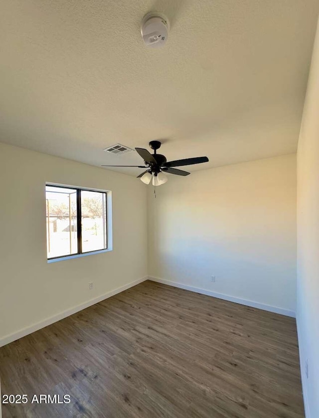 unfurnished room with ceiling fan, dark hardwood / wood-style floors, and a textured ceiling