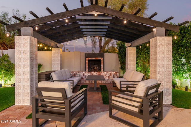 patio terrace at dusk featuring an outdoor living space with a fireplace and a pergola