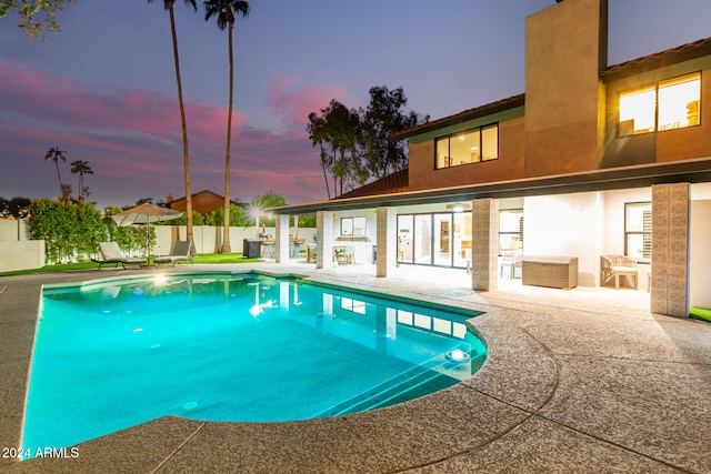 pool at dusk with a patio