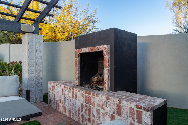 view of patio / terrace with an outdoor brick fireplace and a pergola