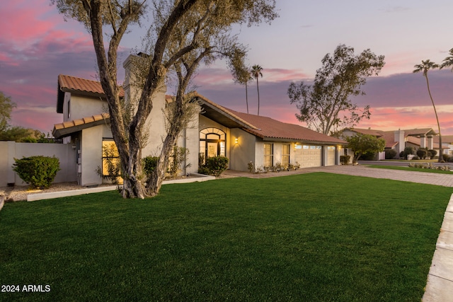 view of front of home featuring a garage and a lawn