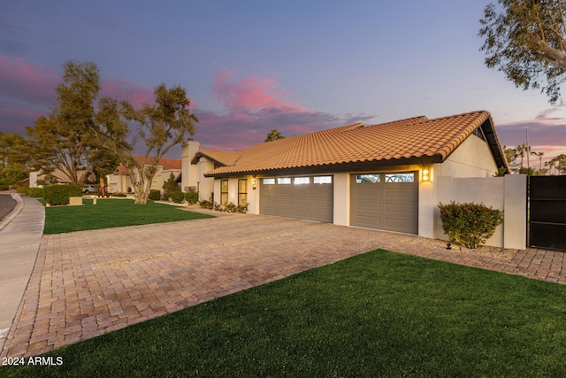 mediterranean / spanish-style home with a garage and a lawn