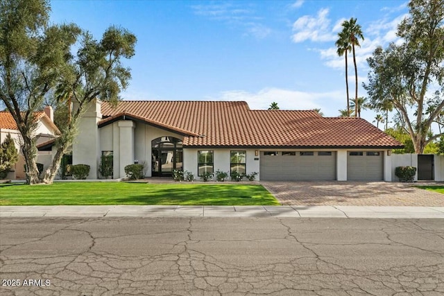 mediterranean / spanish-style house with a garage and a front yard