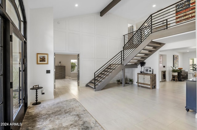 foyer entrance featuring high vaulted ceiling and beamed ceiling