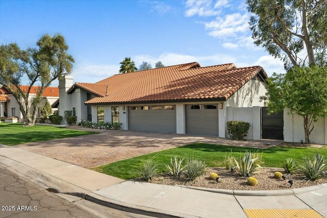 mediterranean / spanish home featuring a garage and a front lawn