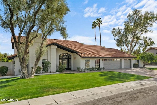 mediterranean / spanish house featuring a garage and a front yard