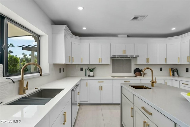 kitchen featuring black electric stovetop, sink, decorative backsplash, and white cabinets