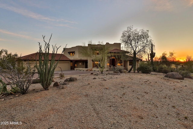 southwest-style home with stucco siding, concrete driveway, and a garage