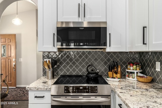 kitchen featuring appliances with stainless steel finishes, backsplash, white cabinetry, and hanging light fixtures