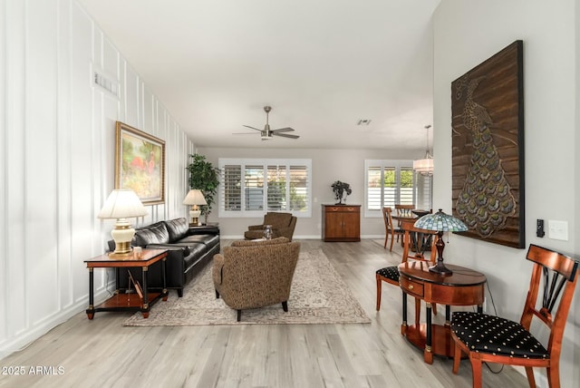 living room featuring ceiling fan and light hardwood / wood-style flooring