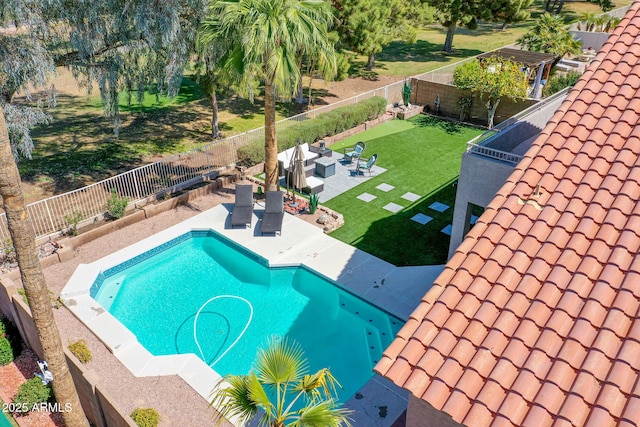 view of swimming pool with a patio area, a yard, a fenced backyard, and a fenced in pool