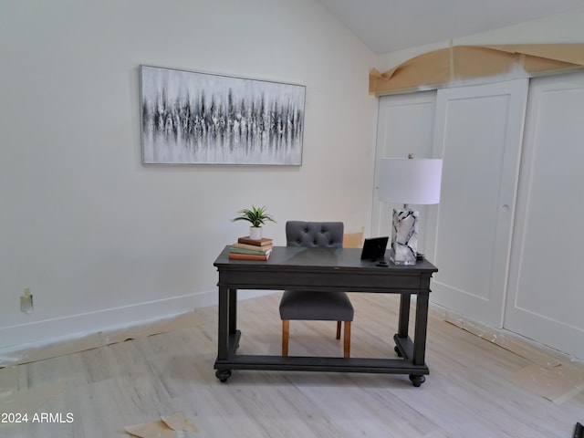 office with light wood-type flooring and vaulted ceiling